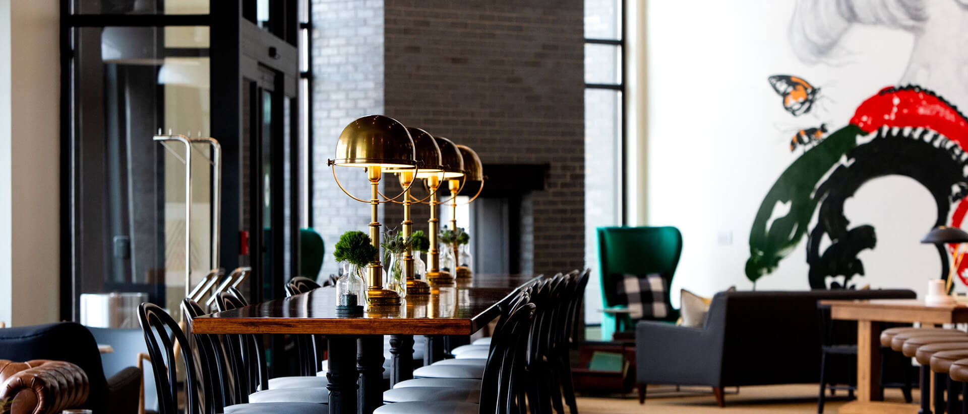 empty hotel lobby communal area featuring bold artwork and bistro furniture